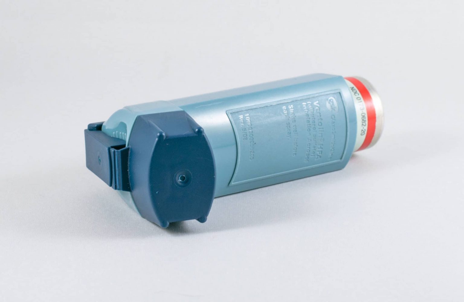 Asthma-inhaler A blue plastic asthma inhaler on its side